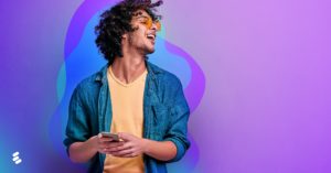 A person using a smartphone in front of a purple backdrop.