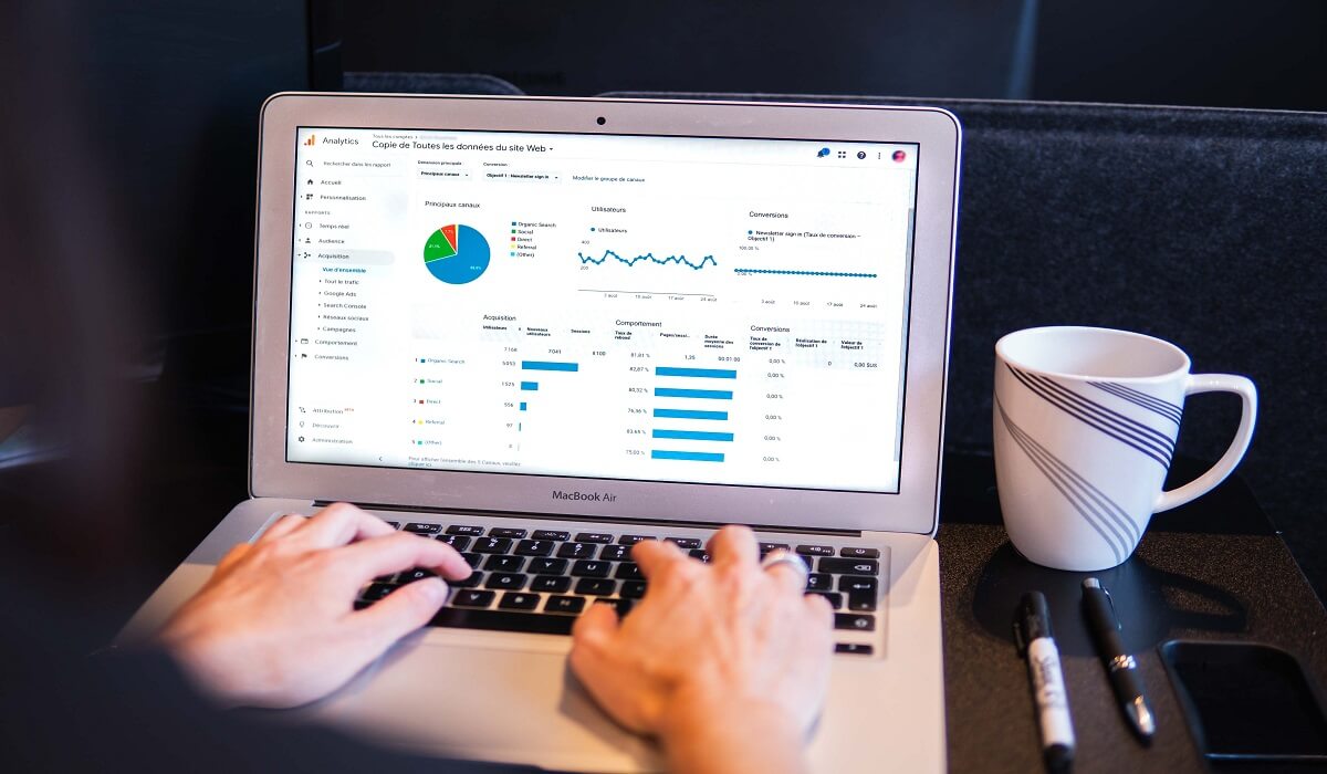 A person looking at graphs on a laptop.